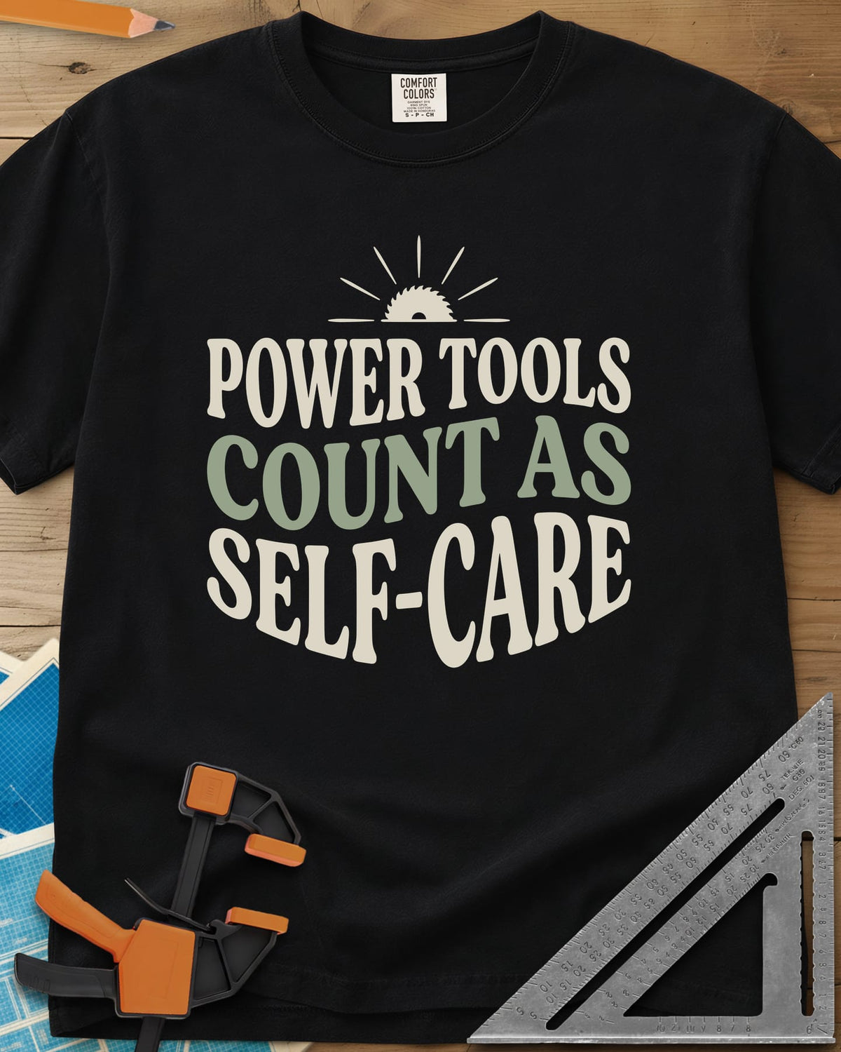 Power Tools Count As Self-Care heavyweight tee in Black, wavy stacked lettering under a half saw blade rising like a sun