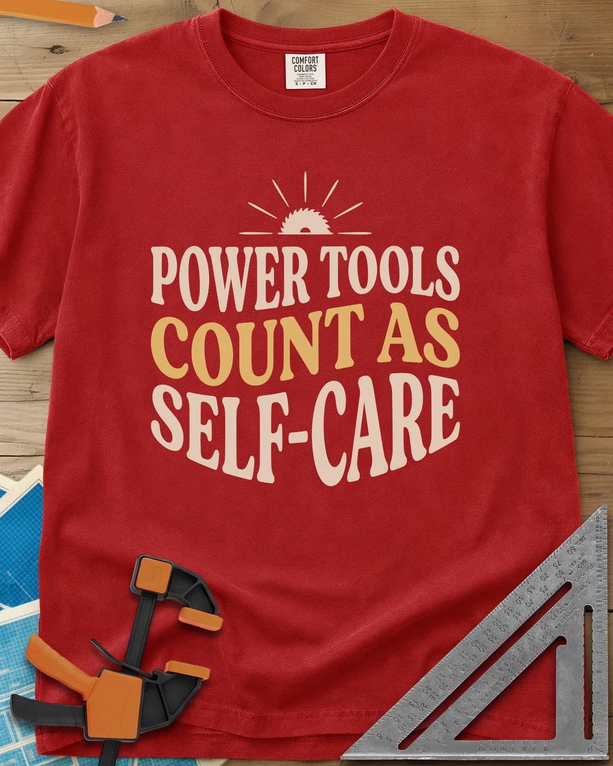 Power Tools Count As Self-Care heavyweight tee in Red, wavy stacked lettering under a half saw blade rising like a sun