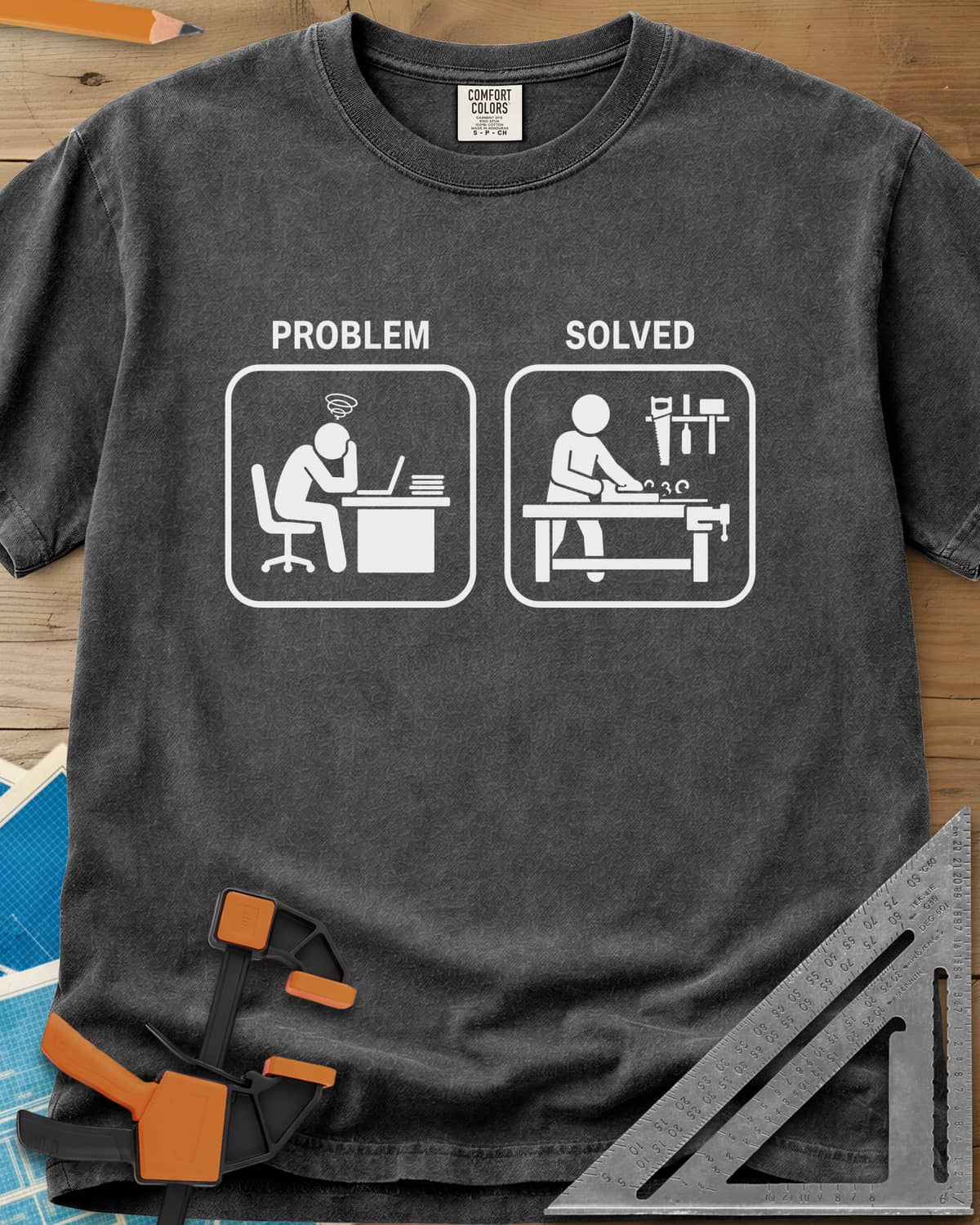 Problem Solved heavyweight tee in Pepper, two pictogram panels, a stressed desk worker and a woodworker planing