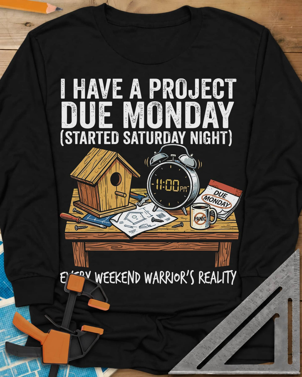 Project Due Monday long sleeve shirt in Black, unfinished birdhouse on a bench with an 11 PM alarm clock and plans