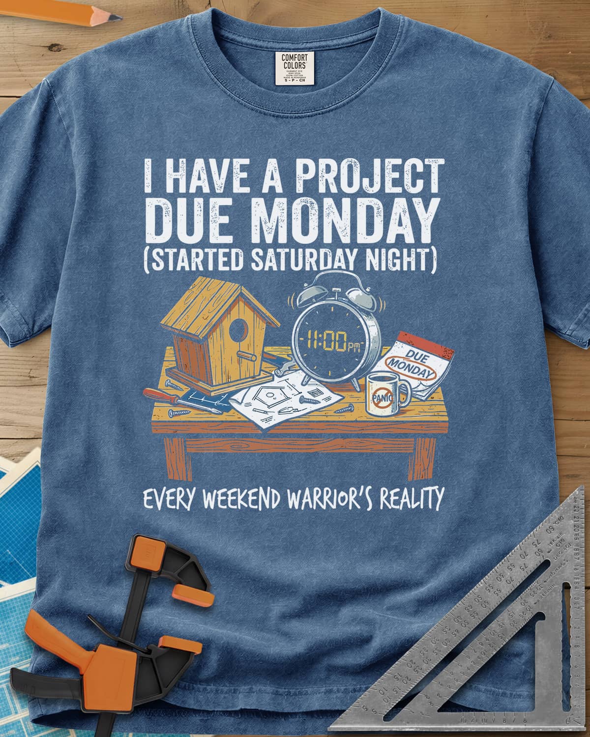 Project Due Monday heavyweight tee in Blue Jean, unfinished birdhouse on a bench with an 11 PM alarm clock and plans
