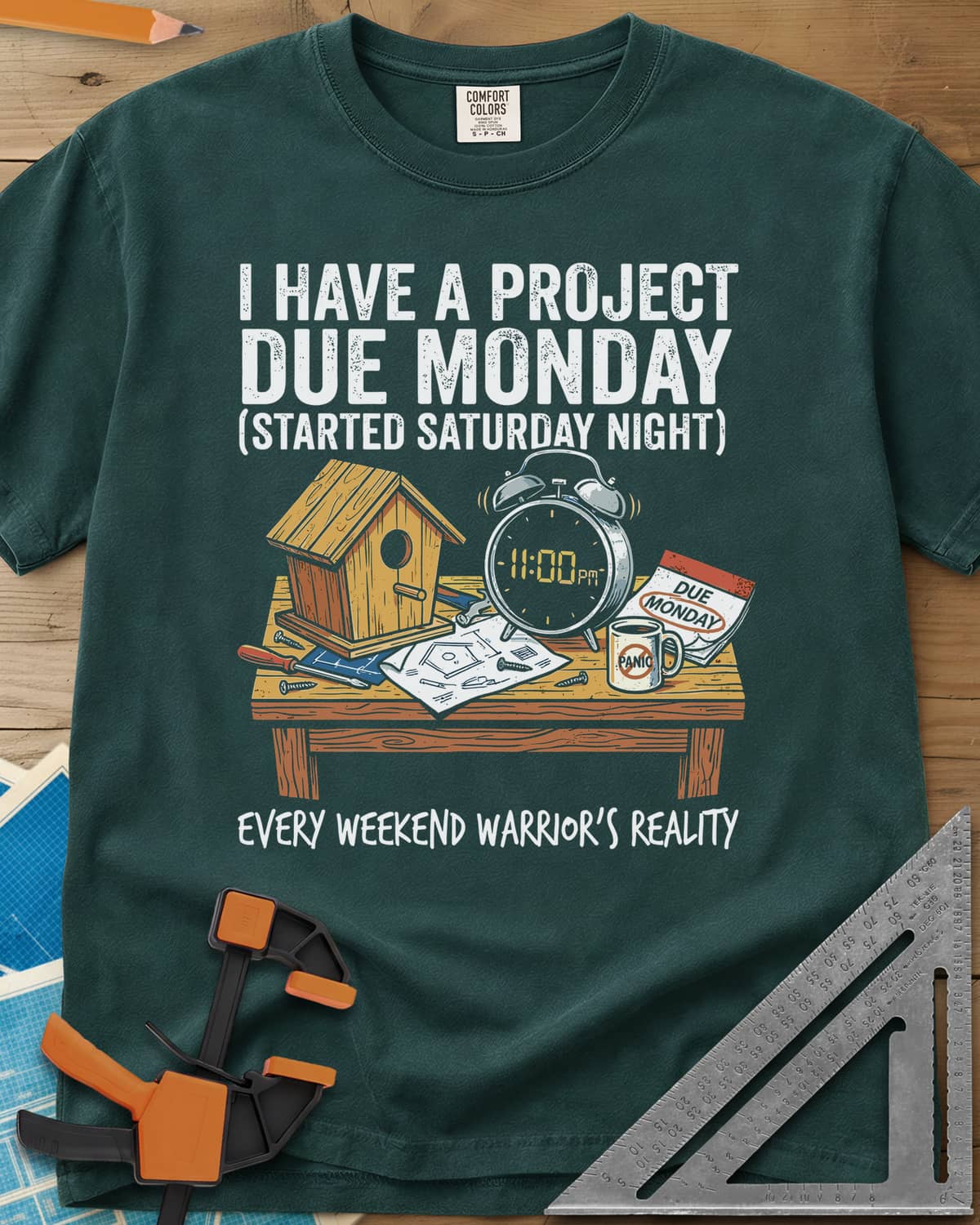 Project Due Monday heavyweight tee in Blue Spruce, unfinished birdhouse on a bench with an 11 PM alarm clock and plans