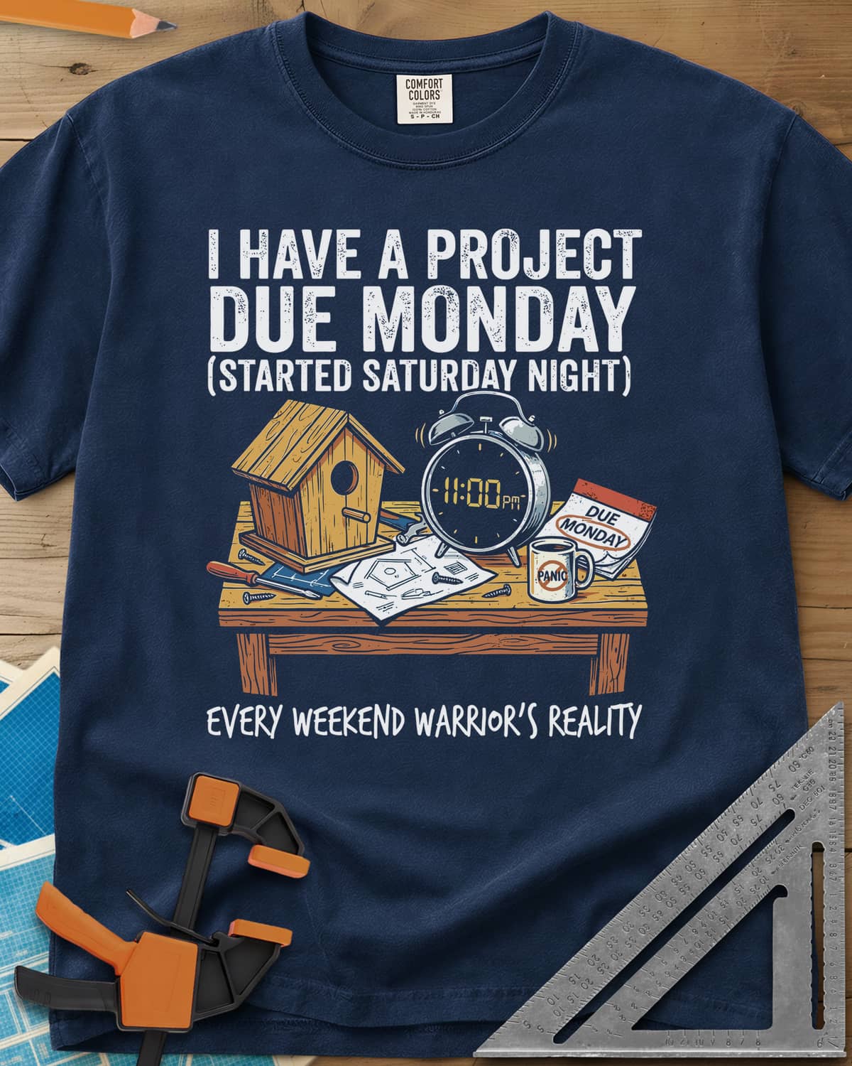 Project Due Monday heavyweight tee in Navy, unfinished birdhouse on a bench with an 11 PM alarm clock and plans