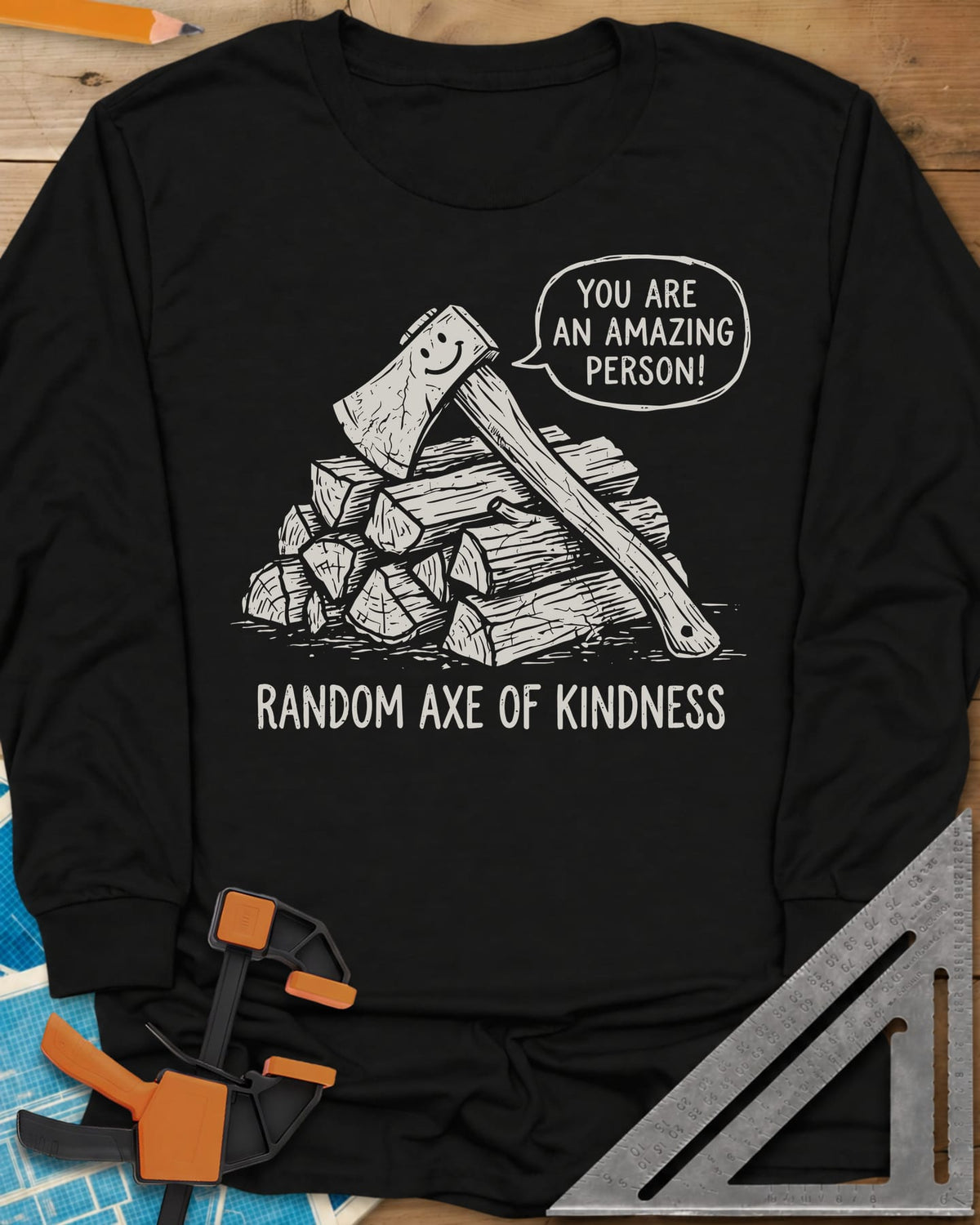 Random Axe of Kindness long sleeve shirt in Black, a smiling axe on a woodpile with an encouraging speech bubble