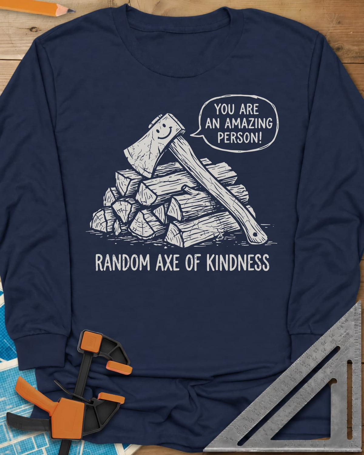 Random Axe of Kindness long sleeve shirt in Navy, a smiling axe on a woodpile with an encouraging speech bubble