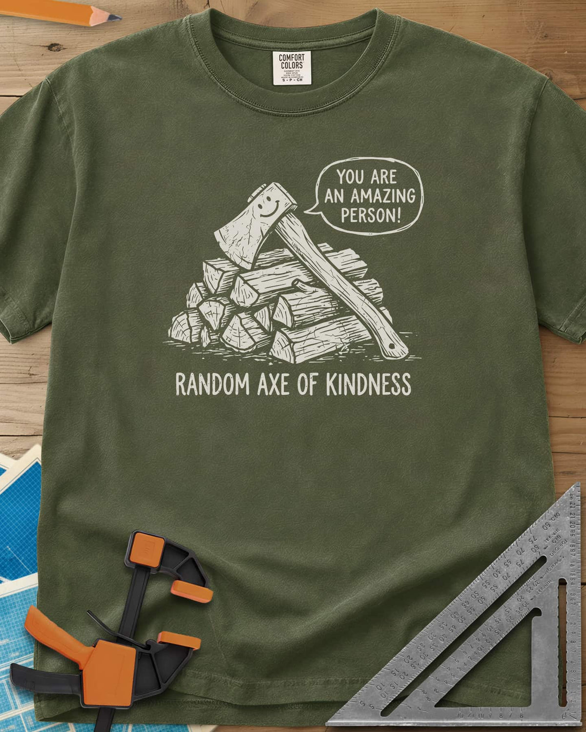 Random Axe of Kindness heavyweight tee in Hemp, a smiling axe on a woodpile with an encouraging speech bubble
