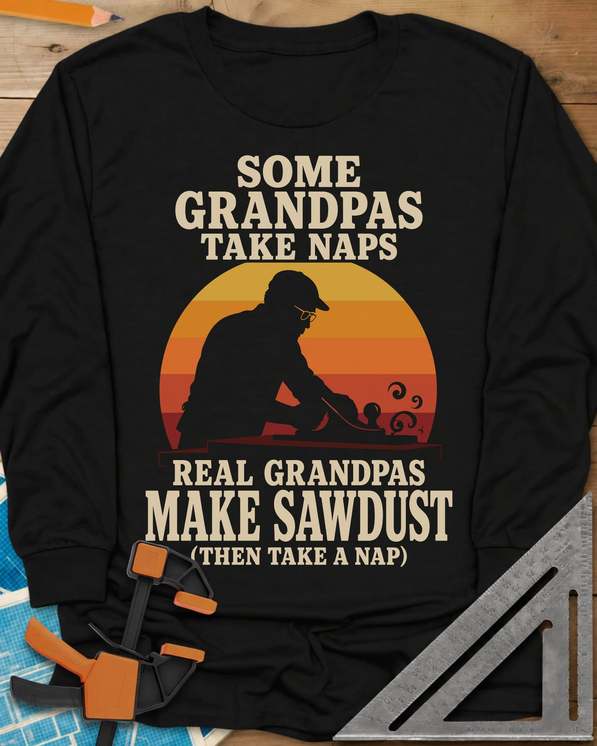 Real Grandpas Make Sawdust long sleeve shirt in Black, striped sunset circle behind a cap-wearing grandpa planing a board