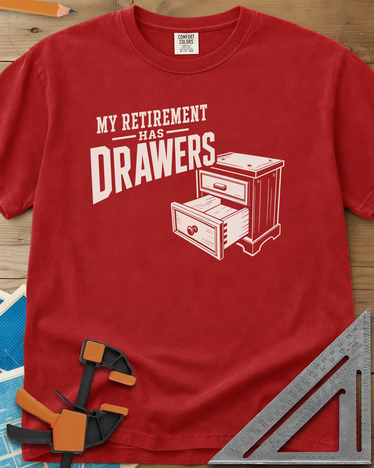 Retirement Drawers heavyweight tee in Red, a small chest of drawers with one drawer pulled open