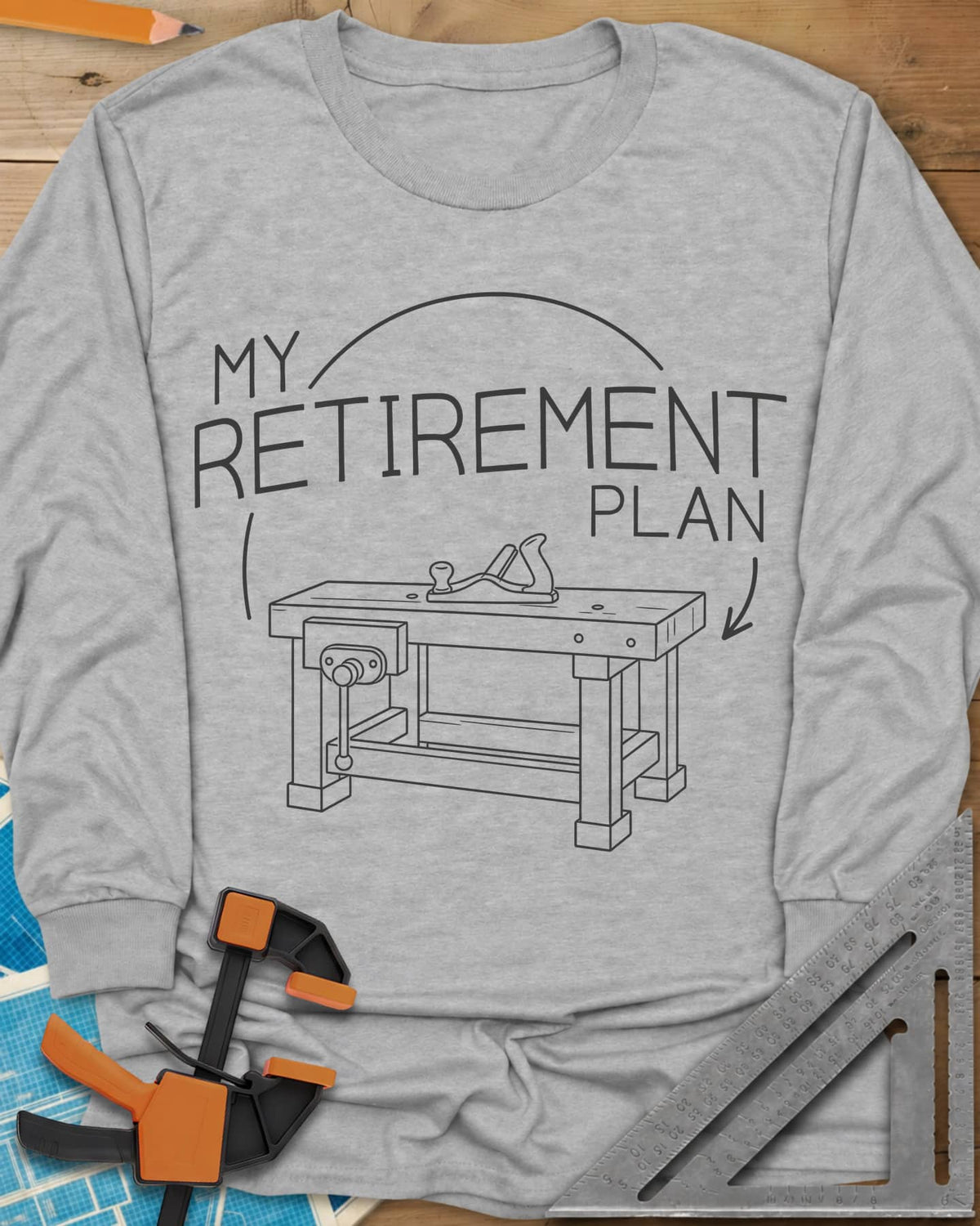 Retirement Plan long sleeve shirt in Sport Grey, line drawing of a woodworking bench with a vise and hand plane