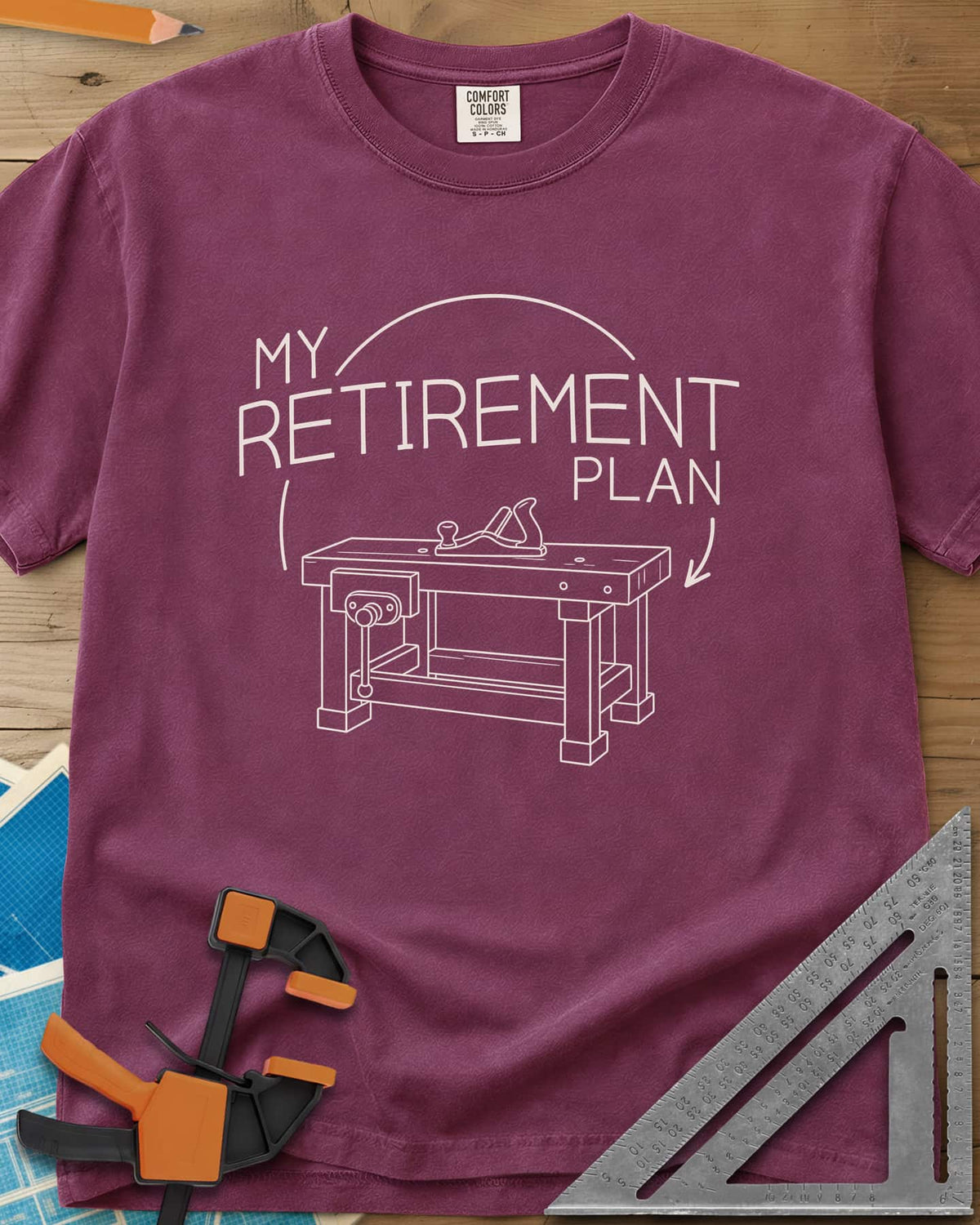Retirement Plan heavyweight tee in Berry, line drawing of a woodworking bench with a vise and hand plane