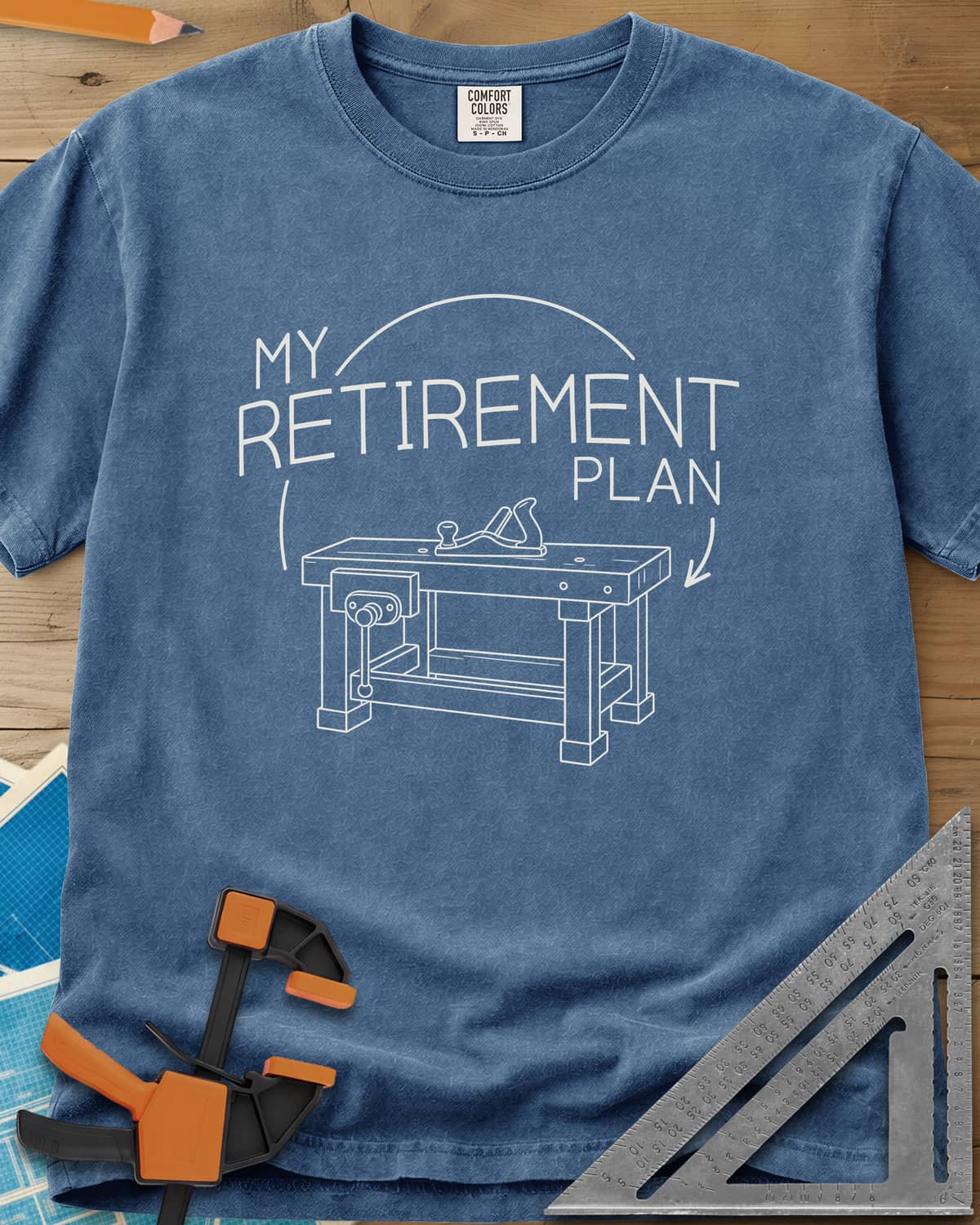Retirement Plan heavyweight tee in Blue Jean, line drawing of a woodworking bench with a vise and hand plane