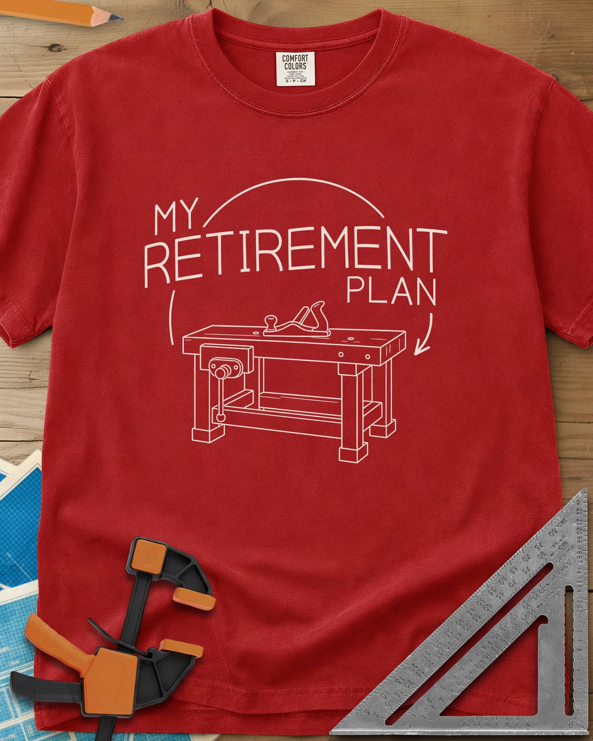 Retirement Plan heavyweight tee in Red, line drawing of a woodworking bench with a vise and hand plane
