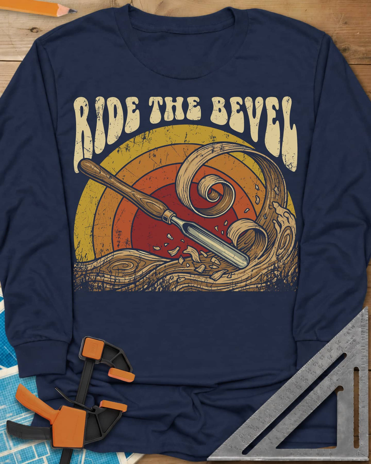 Ride The Bevel long sleeve shirt in Navy, a carving gouge riding a wave of wood curls under a retro sunset