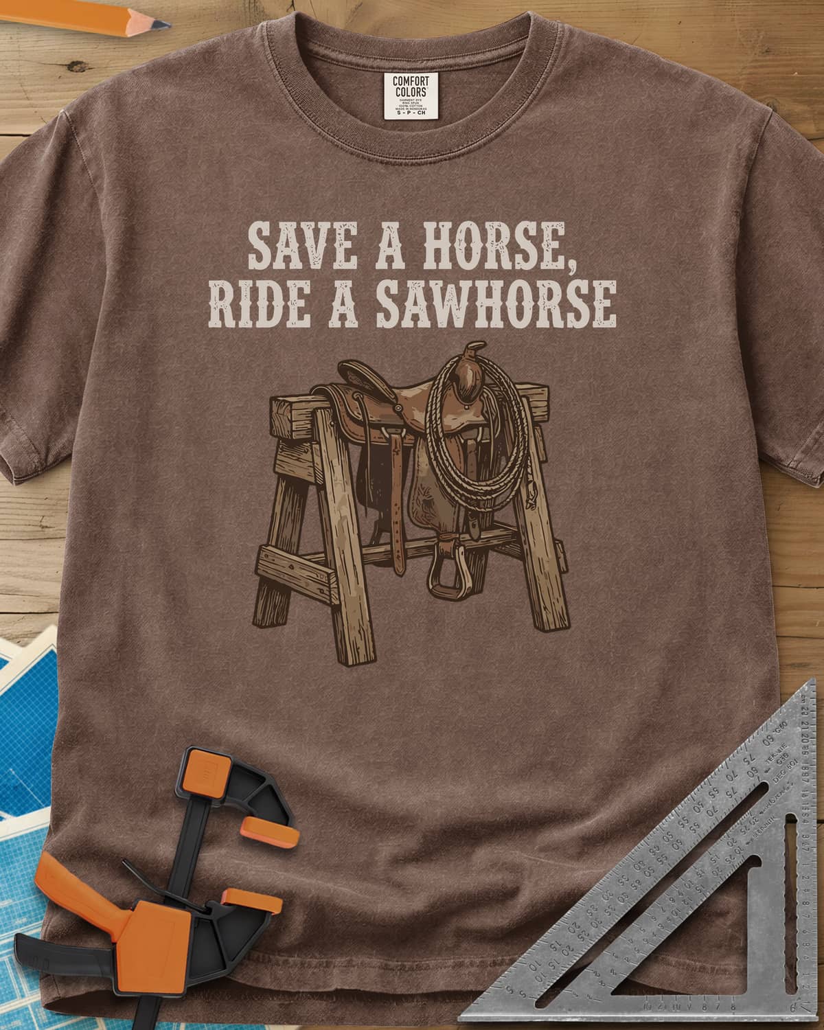 Save a Horse heavyweight tee in Espresso, a western saddle and lasso rope draped over a wooden sawhorse