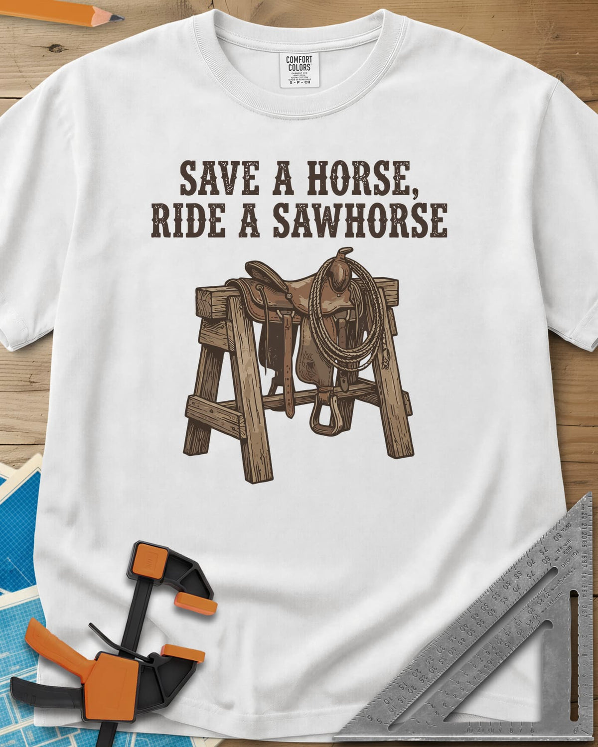 Save a Horse heavyweight tee in White, a western saddle and lasso rope draped over a wooden sawhorse