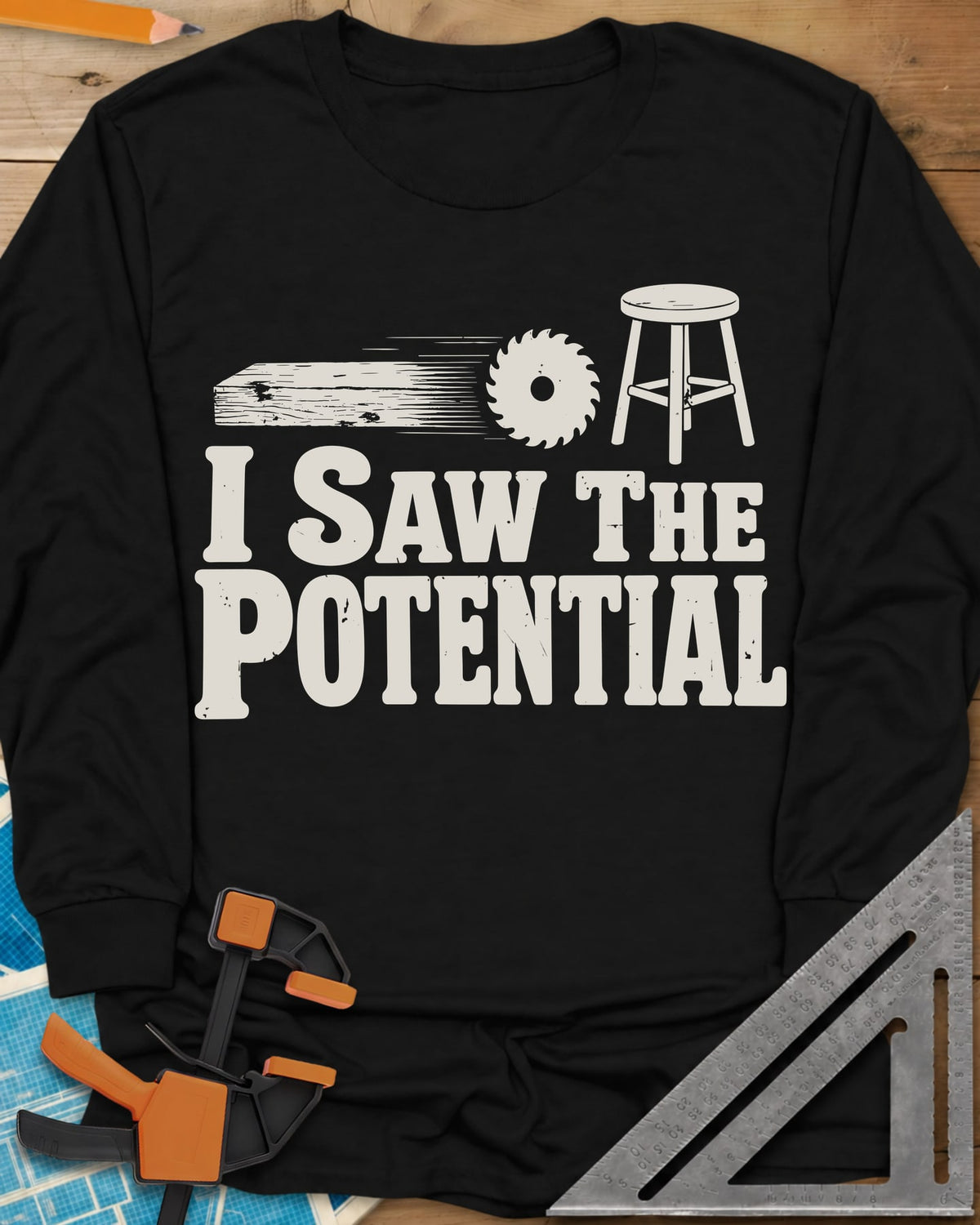 Saw The Potential long sleeve shirt in Black, a speeding plank, a saw blade and a finished stool