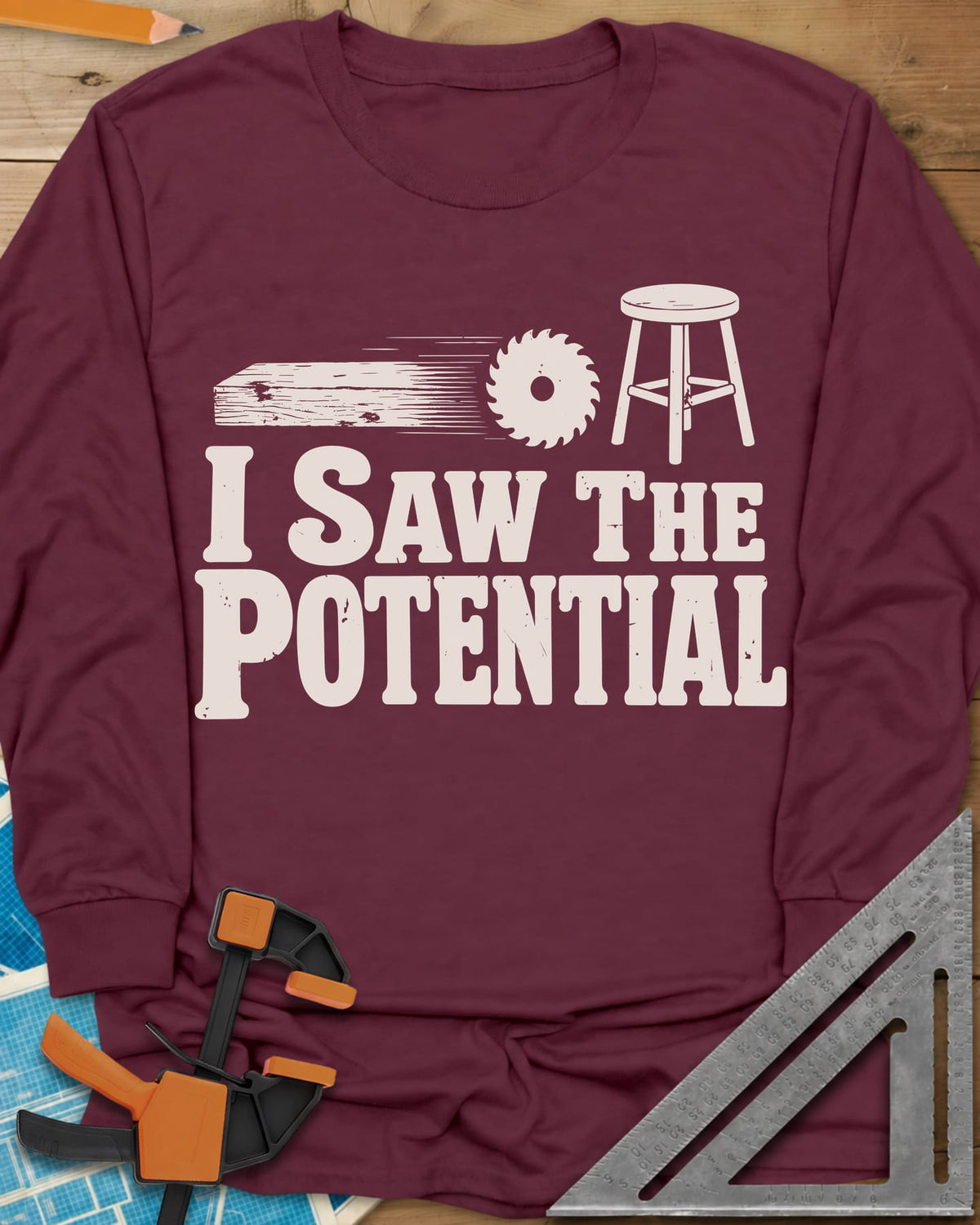 Saw The Potential long sleeve shirt in Maroon, a speeding plank, a saw blade and a finished stool