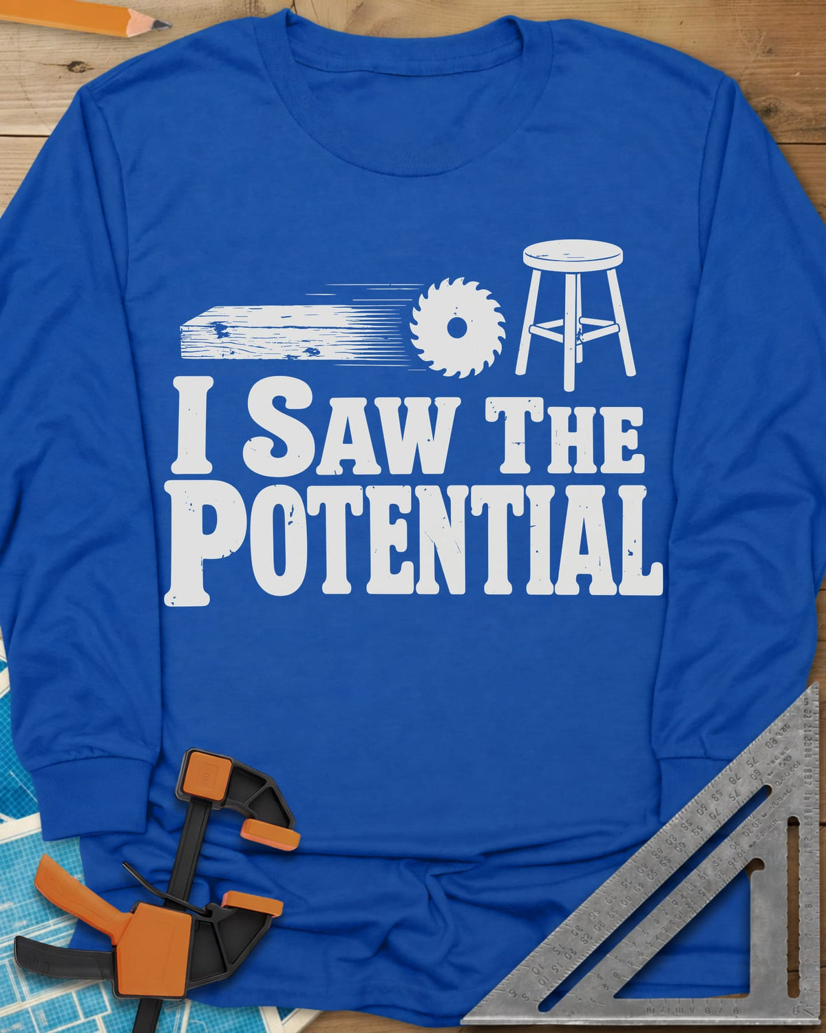 Saw The Potential long sleeve shirt in Royal, a speeding plank, a saw blade and a finished stool