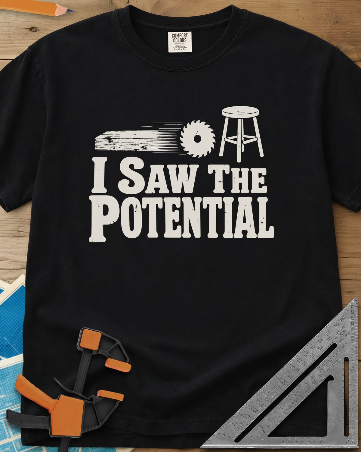 Saw The Potential heavyweight tee in Black, a speeding plank, a saw blade and a finished stool
