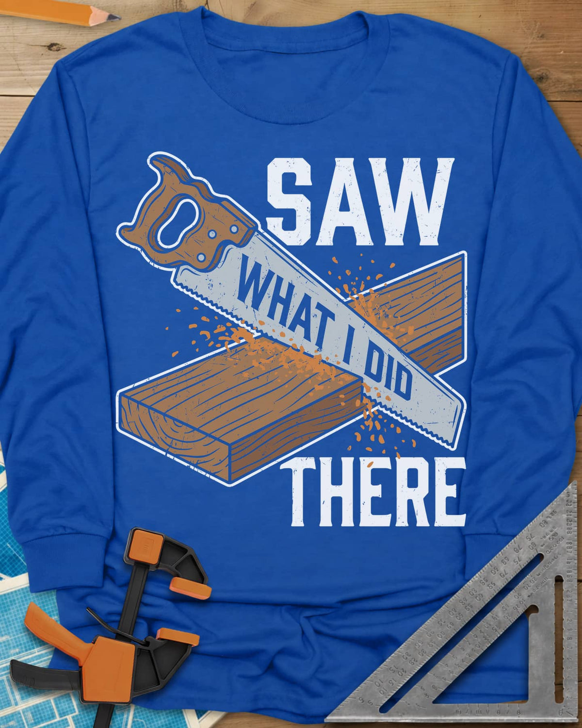 Saw What I Did long sleeve shirt in Royal, a hand saw cutting a plank with WHAT I DID lettered on its blade