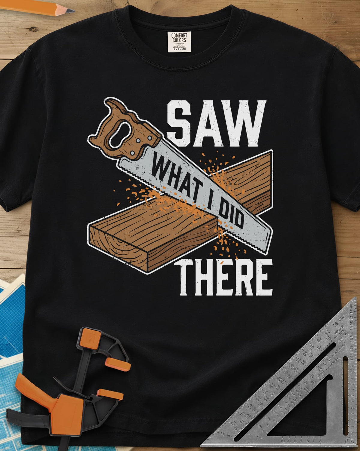 Saw What I Did heavyweight tee in Black, a hand saw cutting a plank with WHAT I DID lettered on its blade