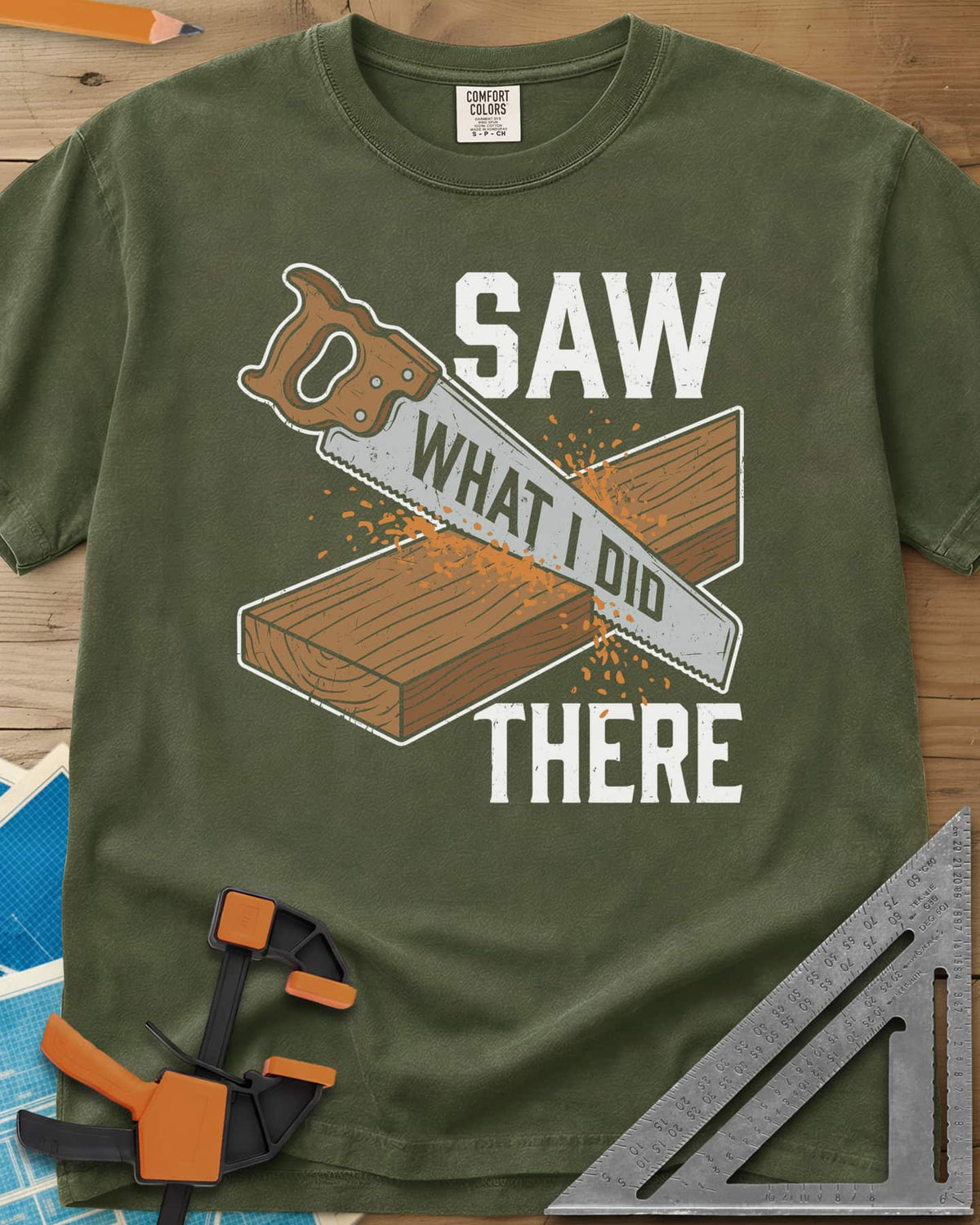Saw What I Did heavyweight tee in Hemp, a hand saw cutting a plank with WHAT I DID lettered on its blade