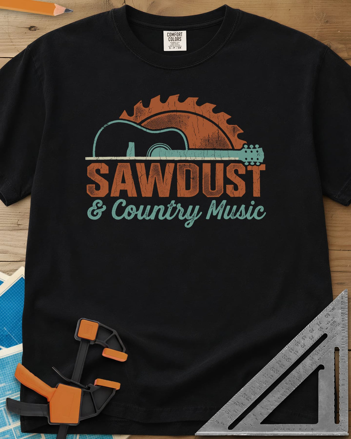 Sawdust And Country Music heavyweight tee in Black, an acoustic guitar in front of a rising saw blade