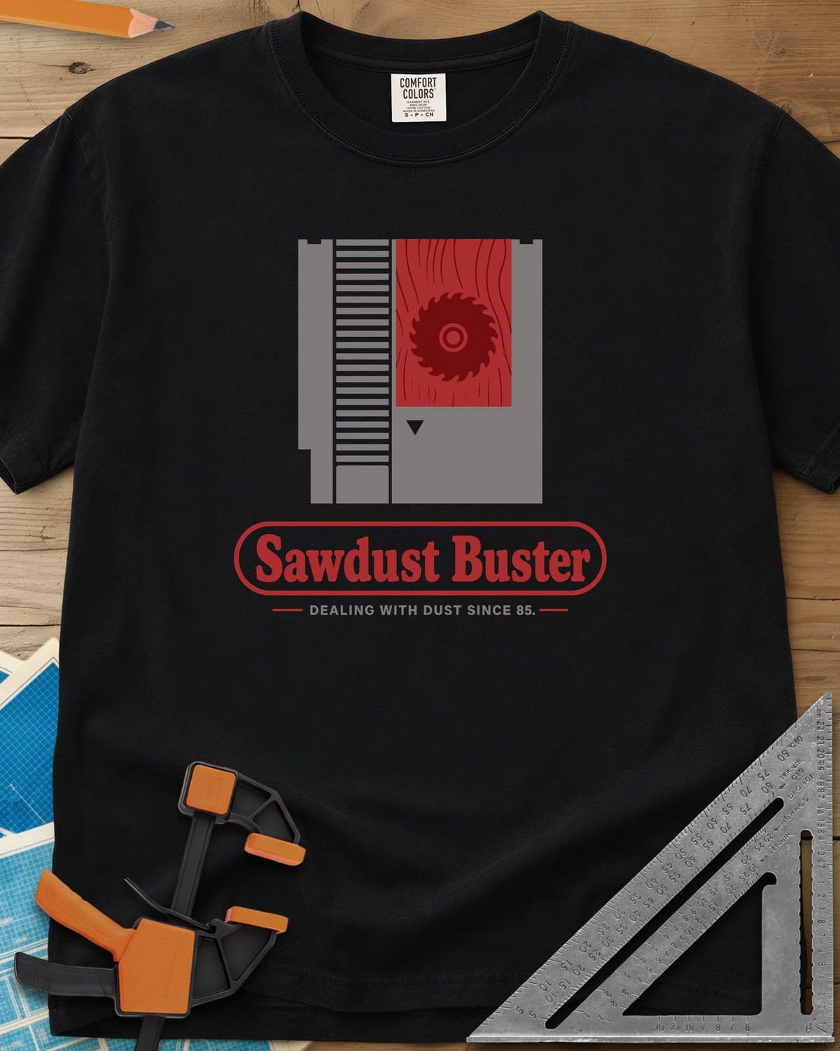 Sawdust Buster heavyweight tee in Black, retro game cartridge with a saw blade on a red wood-grain label