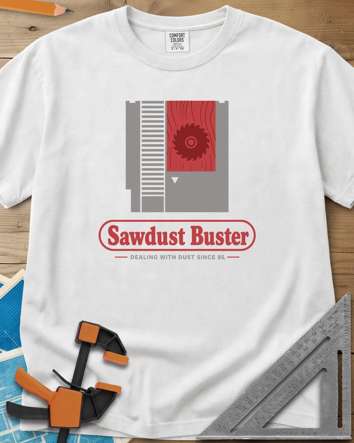 Sawdust Buster heavyweight tee in White, retro game cartridge with a saw blade on a red wood-grain label