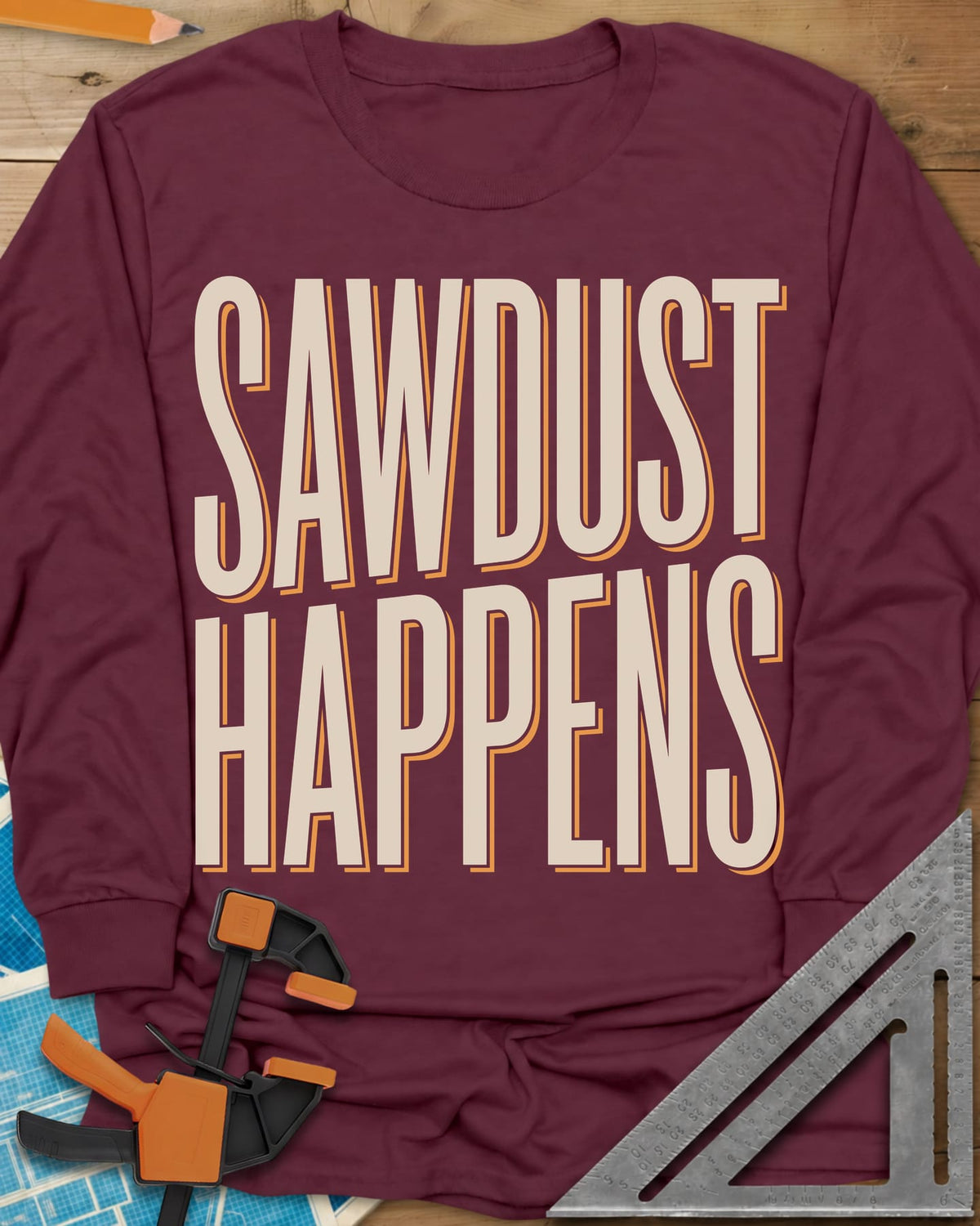 Sawdust Happens long sleeve shirt in Maroon, tall condensed block letters with an offset shadow
