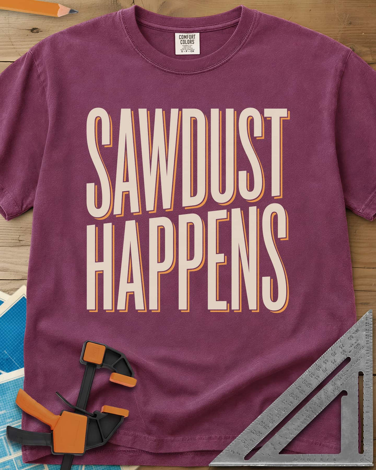 Sawdust Happens heavyweight tee in Berry, tall condensed block letters with an offset shadow