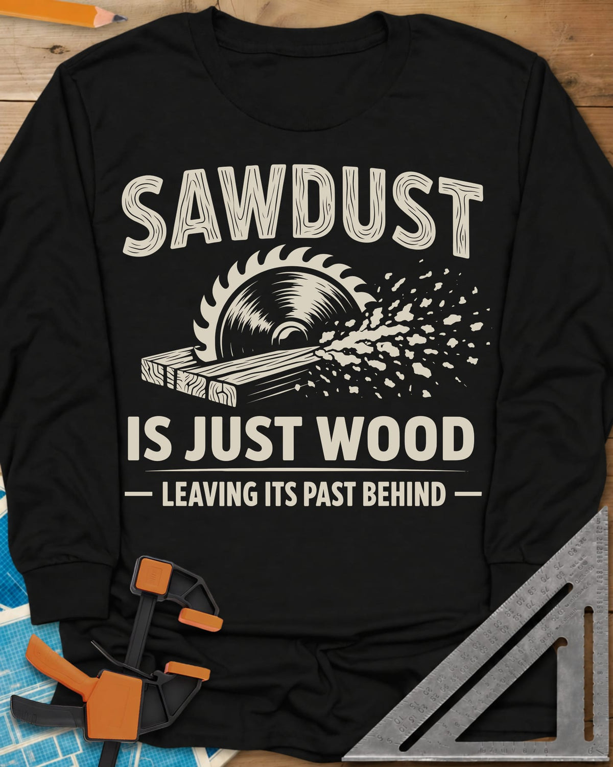 Sawdust Leaving Its Past Behind long sleeve shirt in Black, wood-grain lettering above a circular saw cutting a board