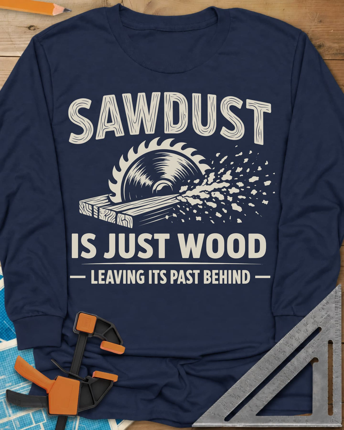 Sawdust Leaving Its Past Behind long sleeve shirt in Navy, wood-grain lettering above a circular saw cutting a board