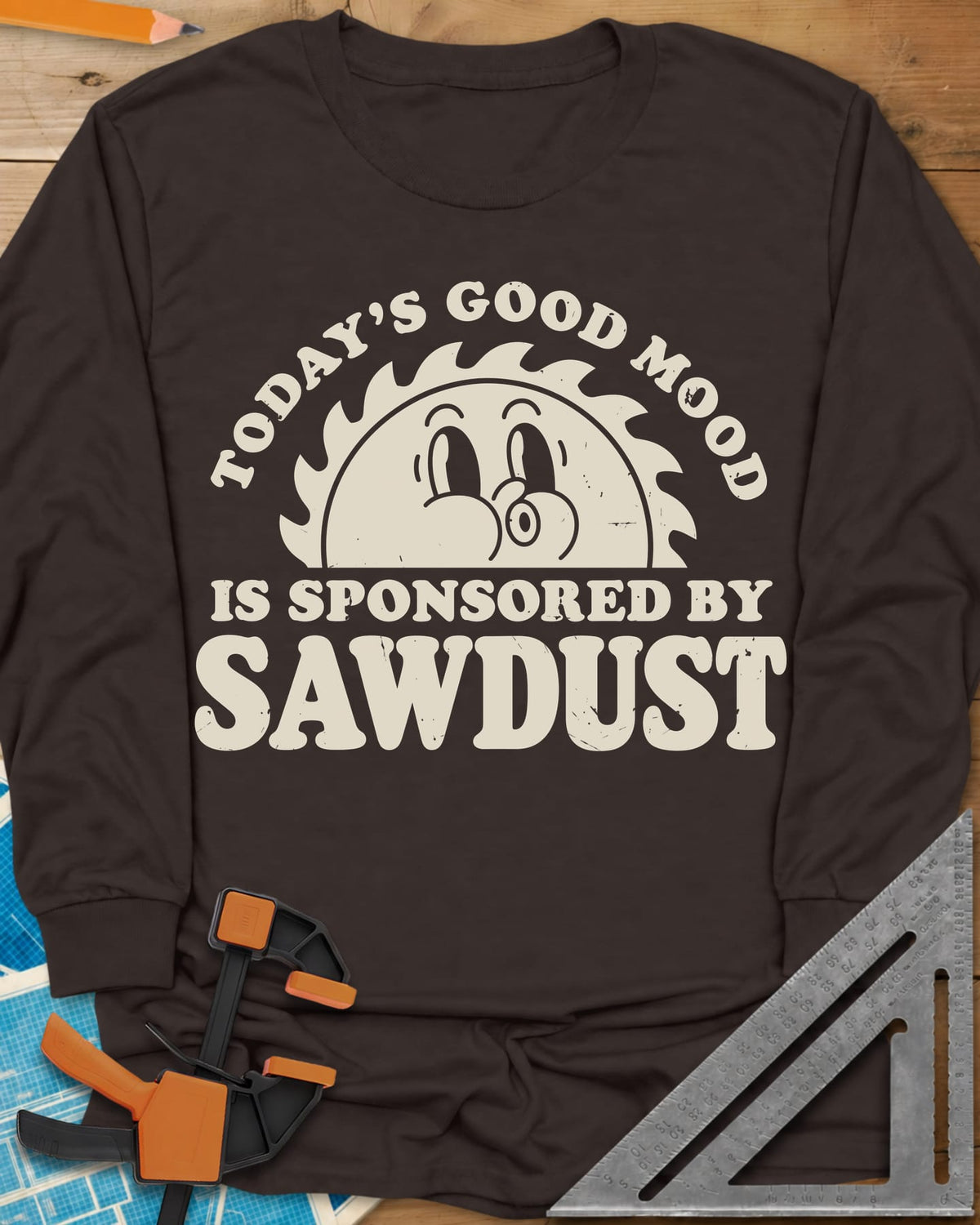 Sawdust Mood long sleeve shirt in Dark Chocolate, half saw blade rising like a sun with a retro cartoon face