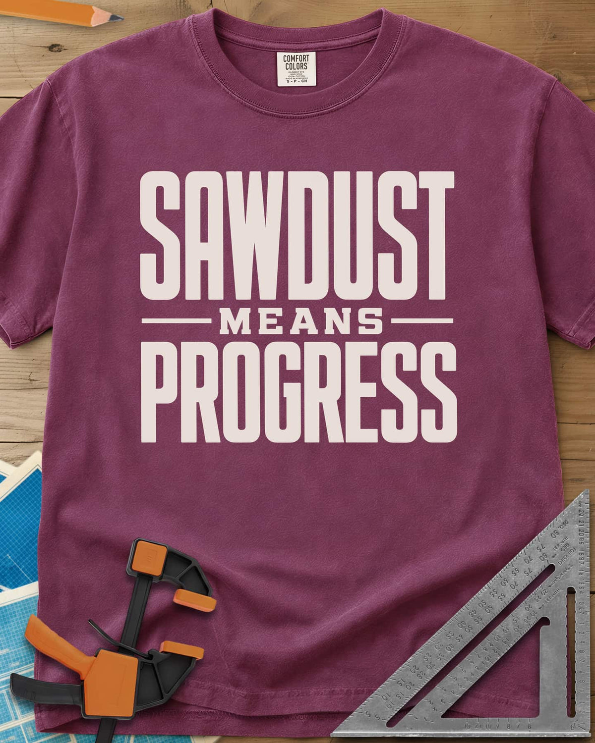Sawdust Progress heavyweight tee in Berry, tall block letters with a small MEANS set between two rules