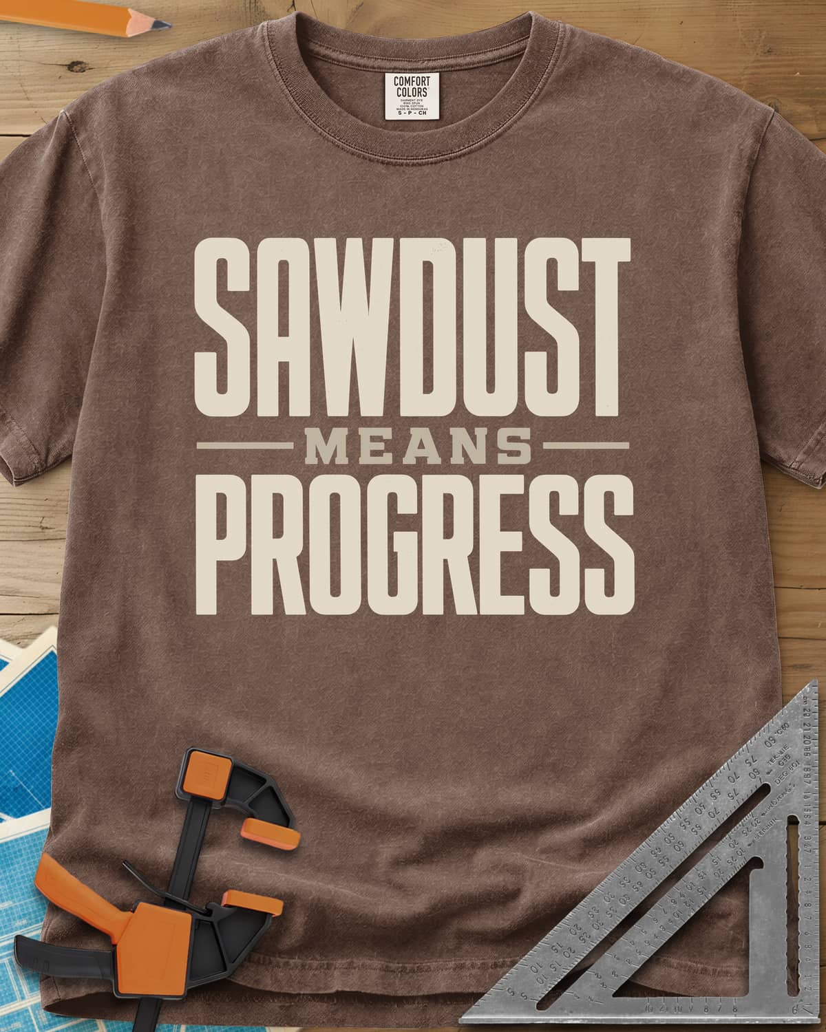 Sawdust Progress heavyweight tee in Espresso, tall block letters with a small MEANS set between two rules