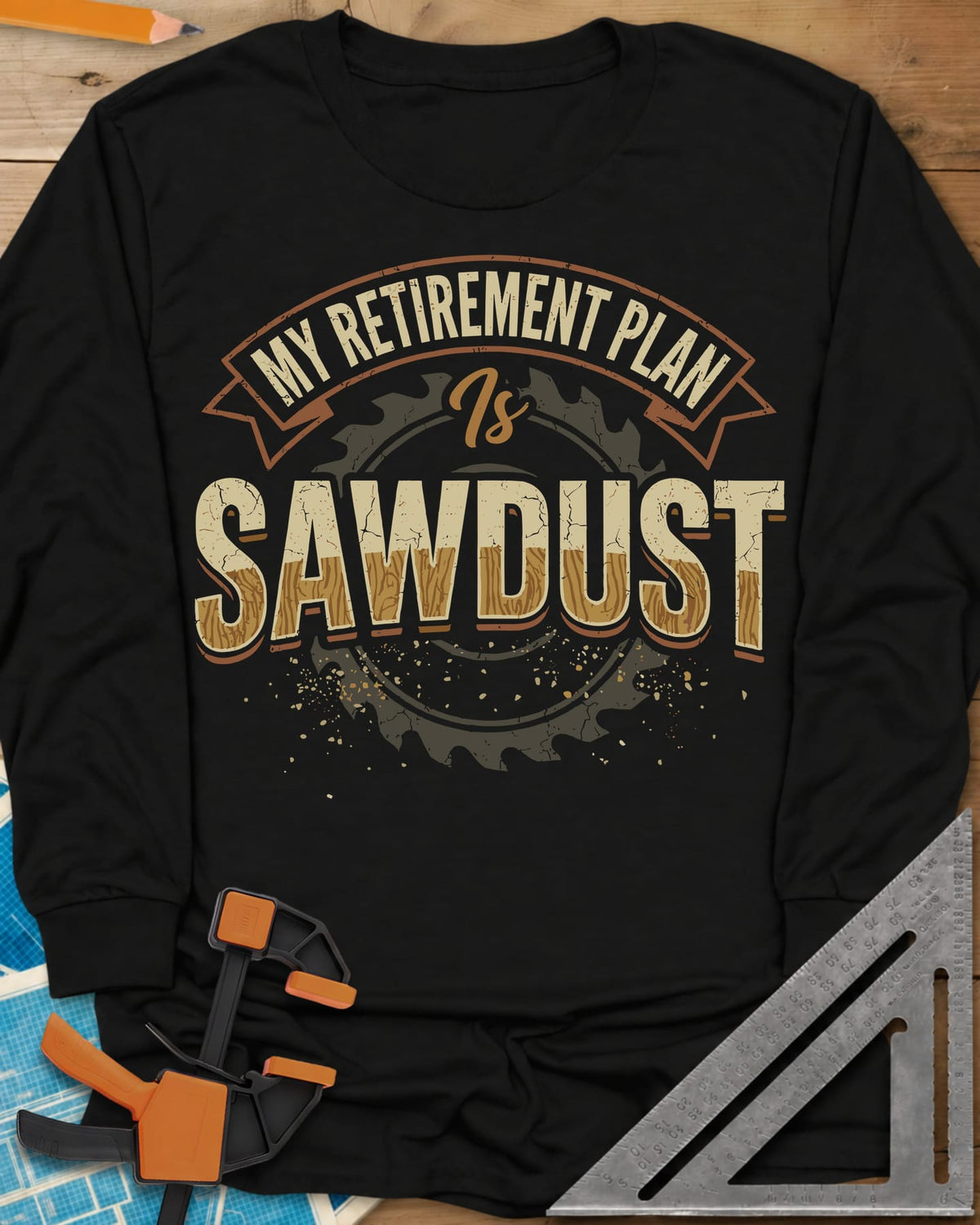 Sawdust Retirement long sleeve shirt in Black, a ribbon banner over a saw blade, cracked wood-grain letters