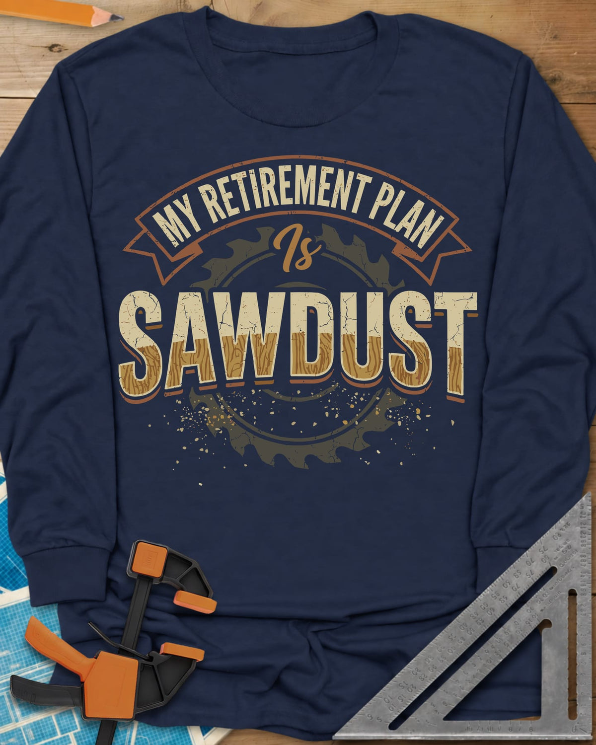 Sawdust Retirement long sleeve shirt in Navy, a ribbon banner over a saw blade, cracked wood-grain letters