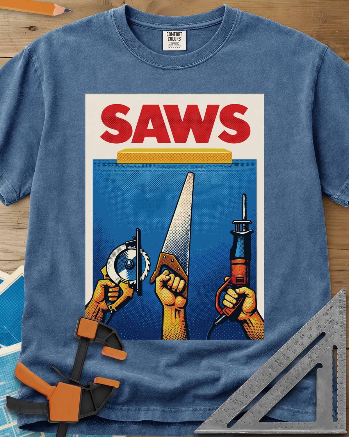Saws Tool Pride heavyweight tee in Blue Jean, three hands raising a circular saw, handsaw and reciprocating saw