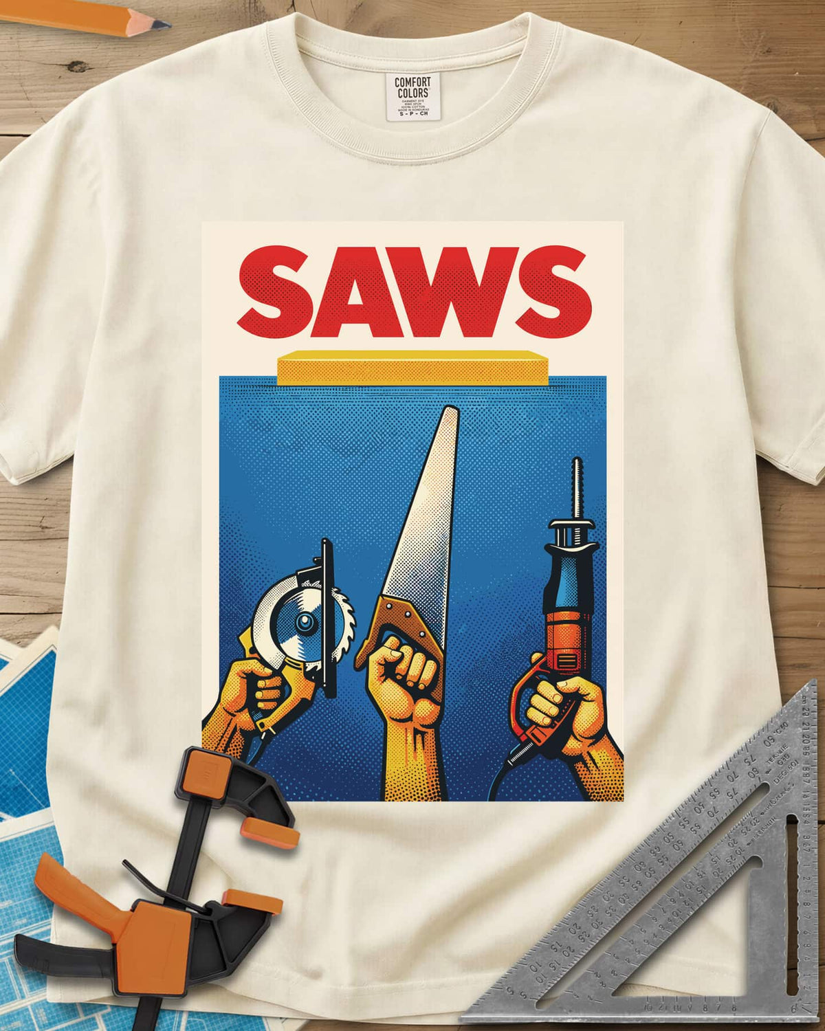 Saws Tool Pride heavyweight tee in Ivory, three hands raising a circular saw, handsaw and reciprocating saw