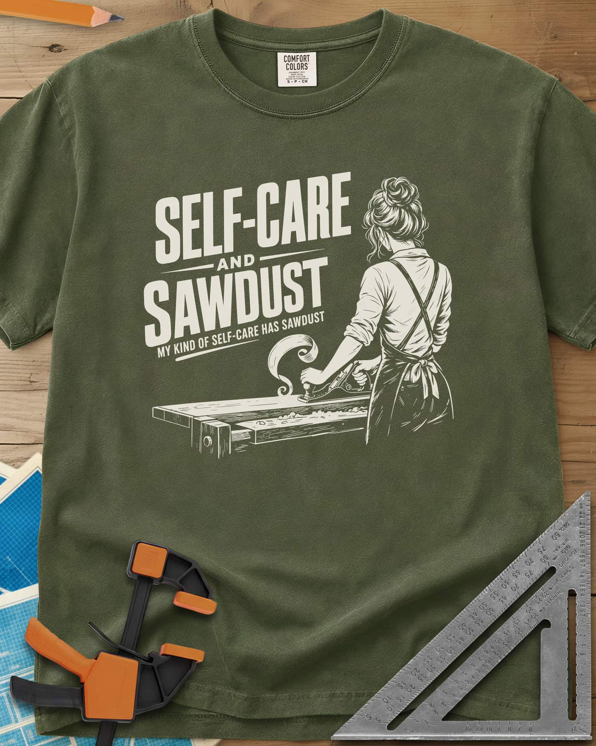 Self-Care & Sawdust heavyweight tee in Hemp, a woman at a workbench running a hand plane, shaving curling up