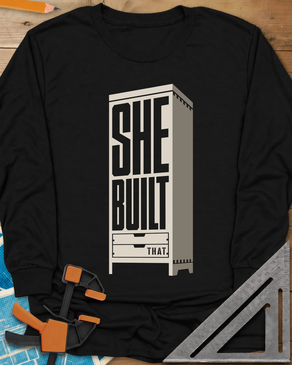 She Built long sleeve shirt in Black, stacked letters set into a tall cabinet with two drawers