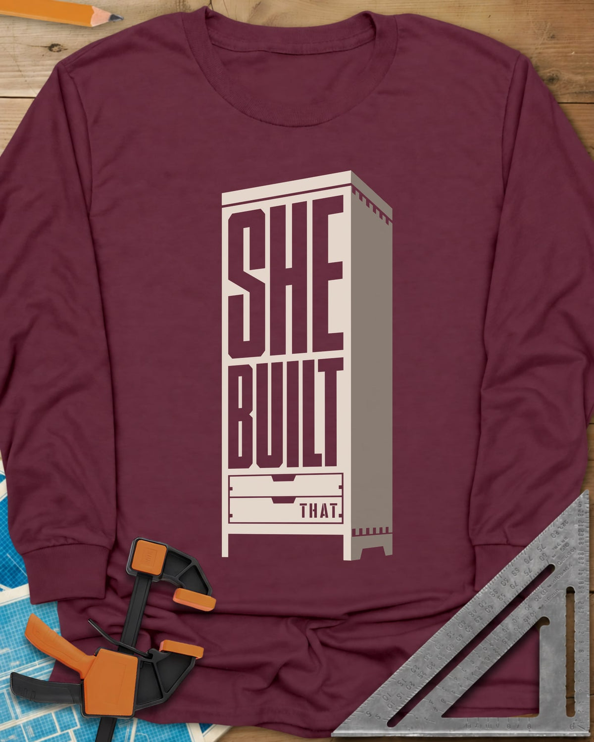 She Built long sleeve shirt in Maroon, stacked letters set into a tall cabinet with two drawers