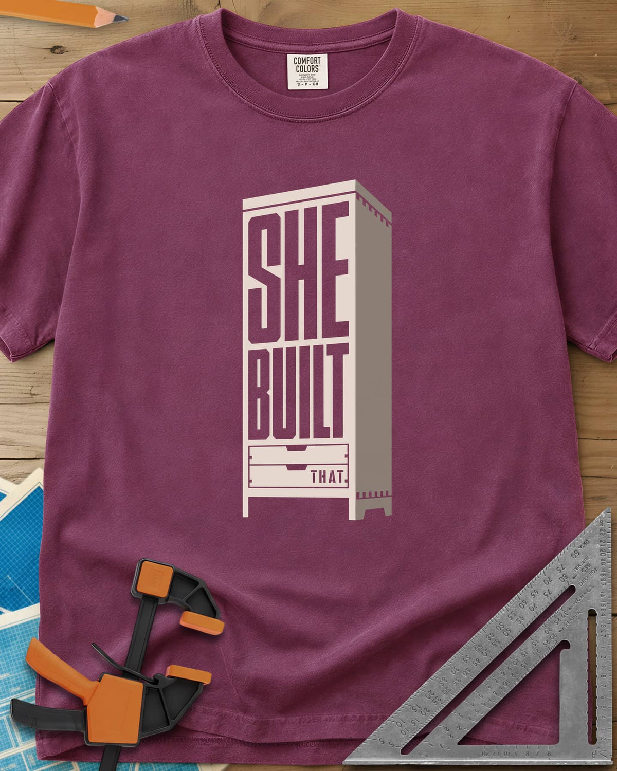 She Built heavyweight tee in Berry, stacked letters set into a tall cabinet with two drawers