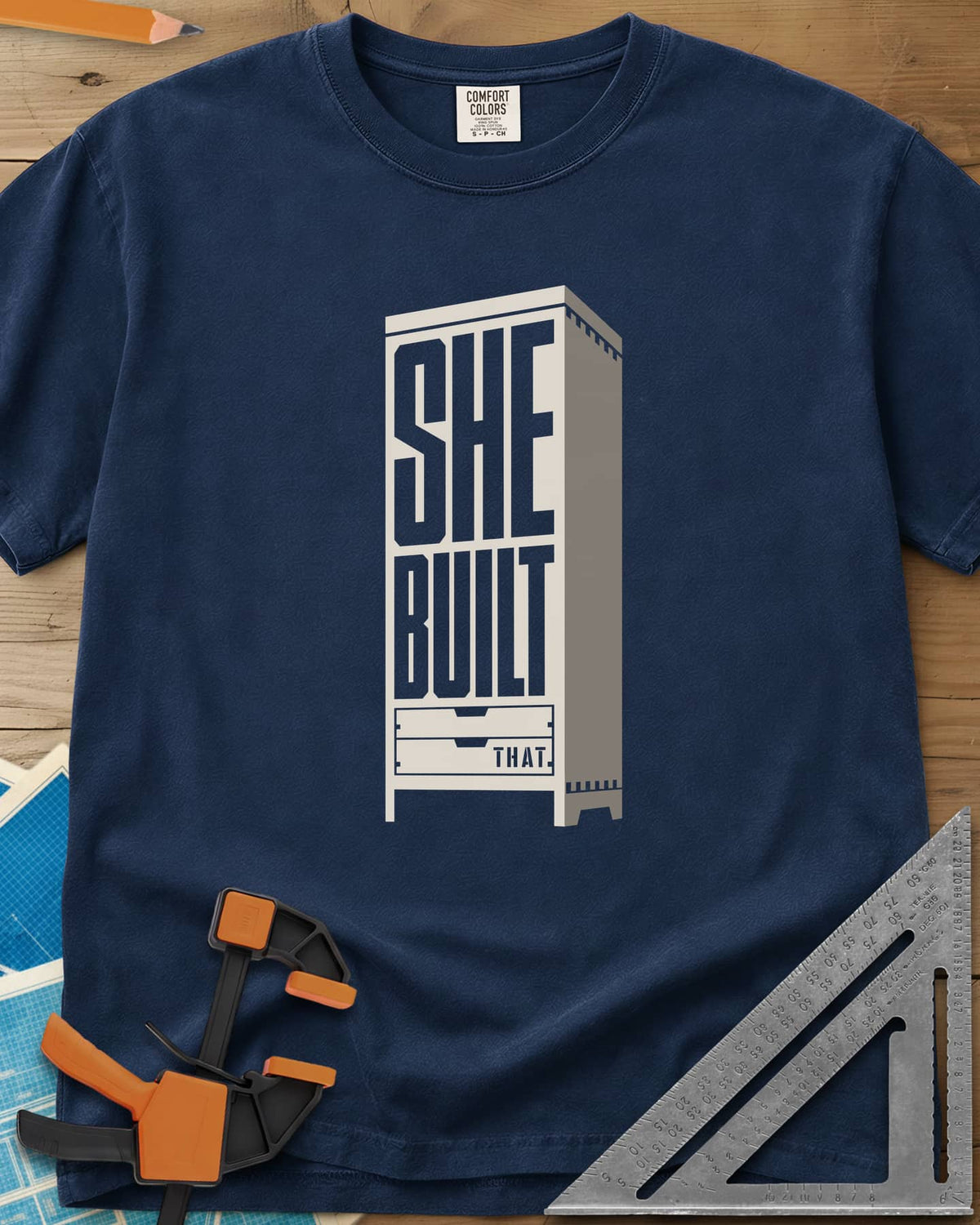 She Built heavyweight tee in Navy, stacked letters set into a tall cabinet with two drawers