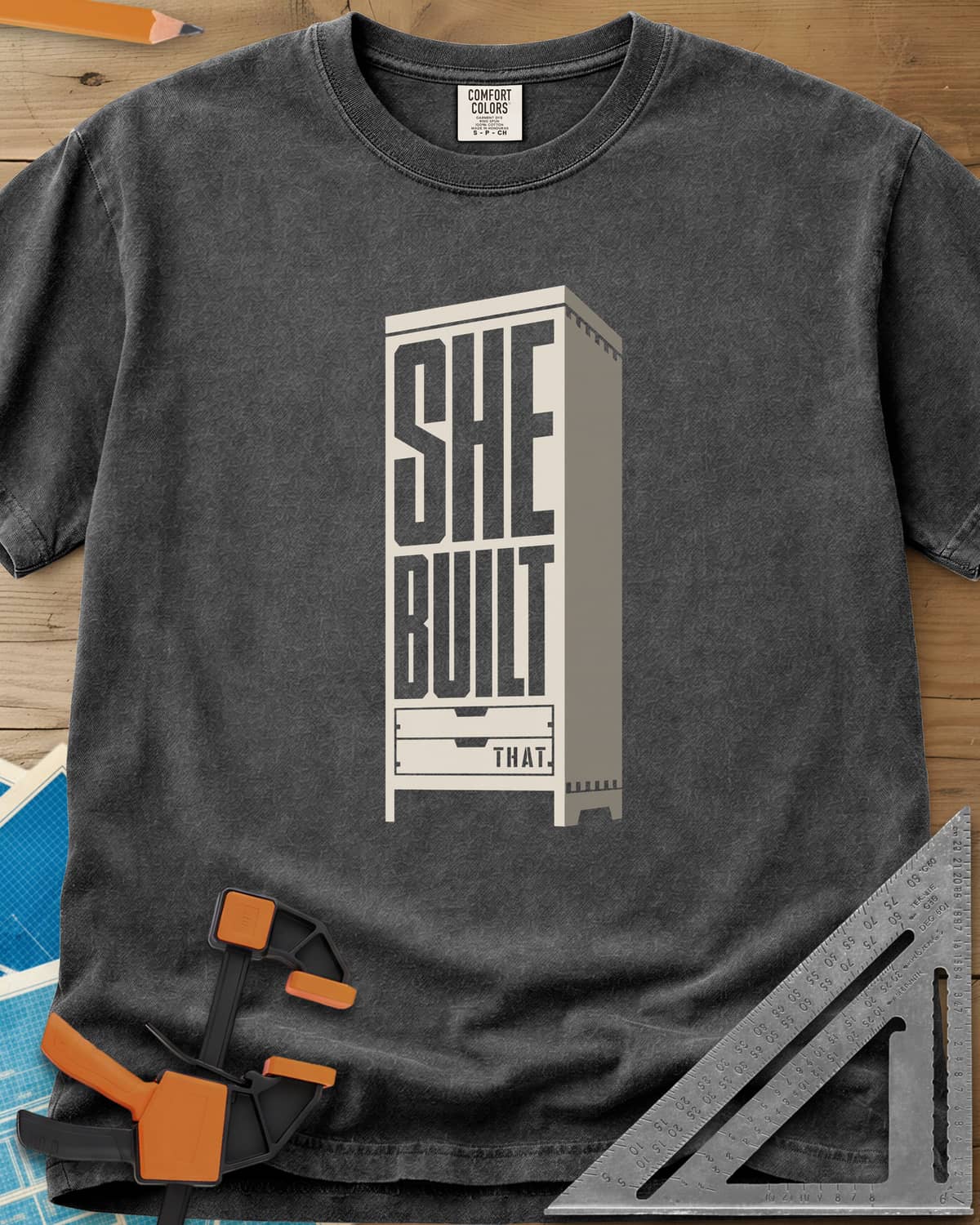 She Built heavyweight tee in Pepper, stacked letters set into a tall cabinet with two drawers