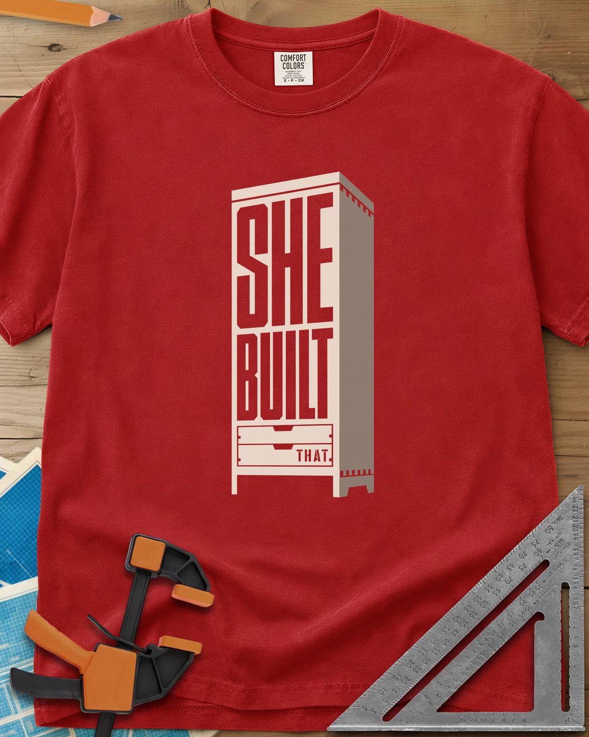 She Built heavyweight tee in Red, stacked letters set into a tall cabinet with two drawers