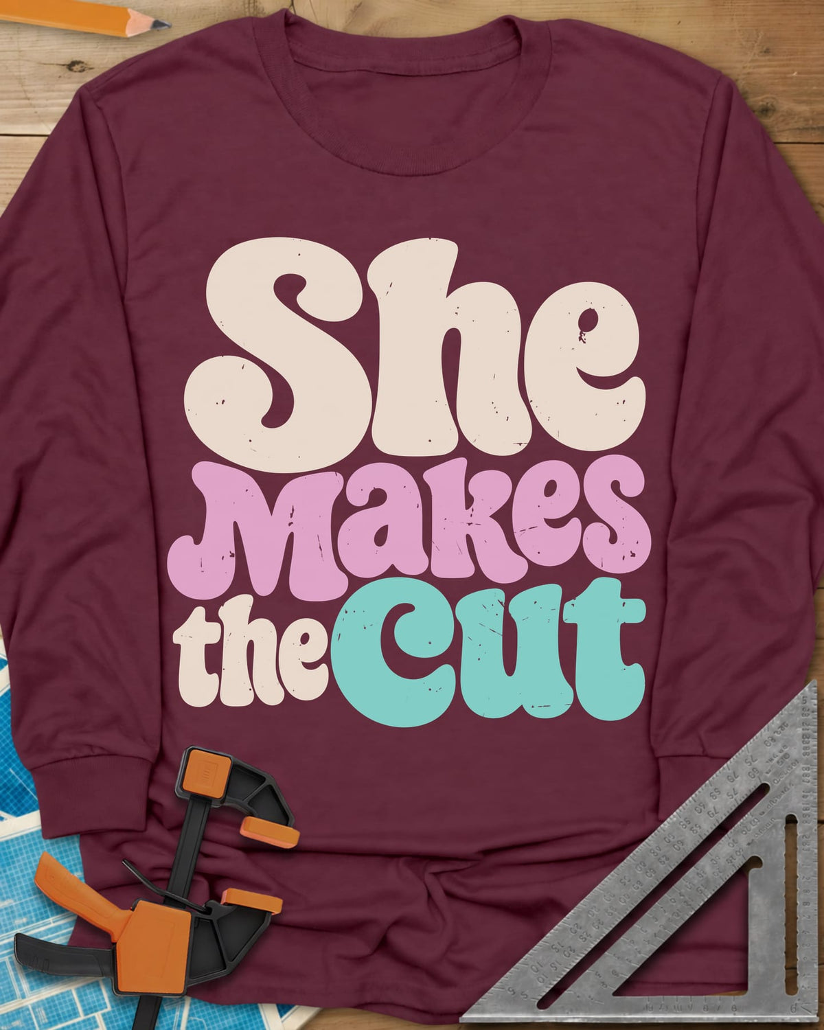 She Makes The Cut long sleeve shirt in Maroon, chunky retro lettering in cream, pink and teal