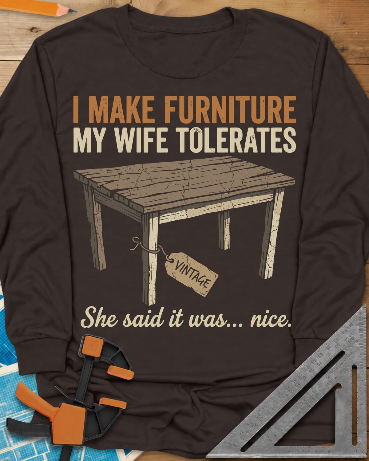 She Said It Was Nice long sleeve shirt in Dark Chocolate, a weathered rustic table with a VINTAGE tag tied to one leg
