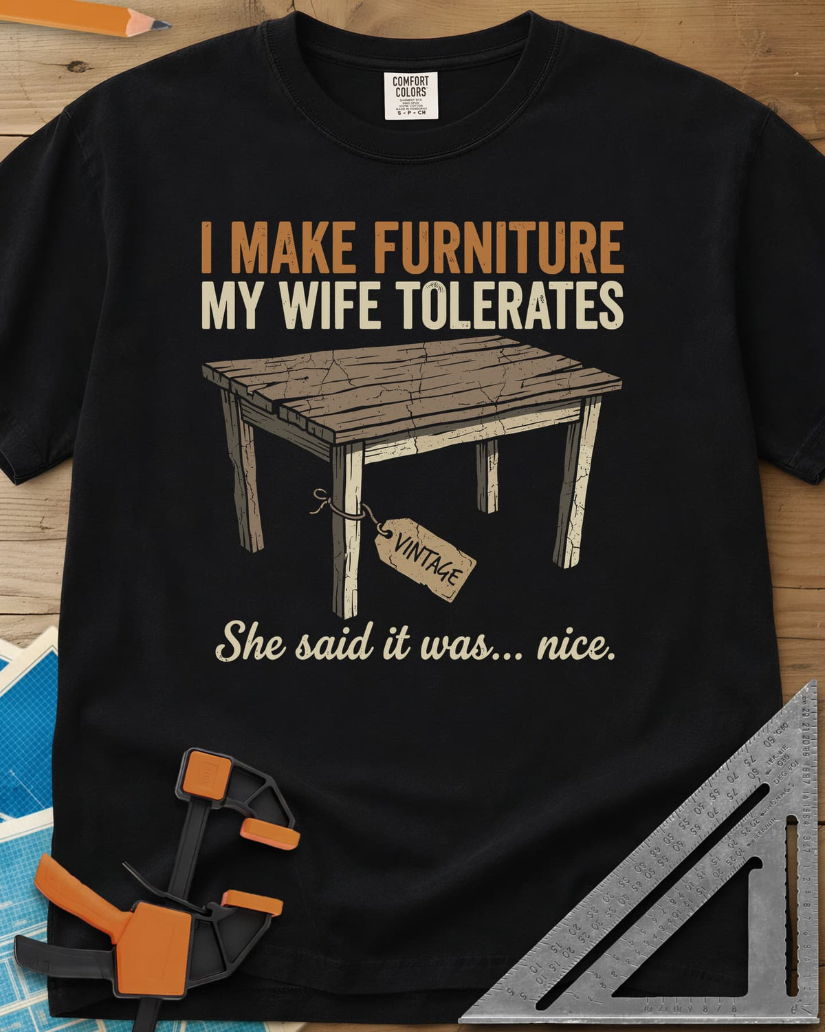 She Said It Was Nice heavyweight tee in Black, a weathered rustic table with a VINTAGE tag tied to one leg